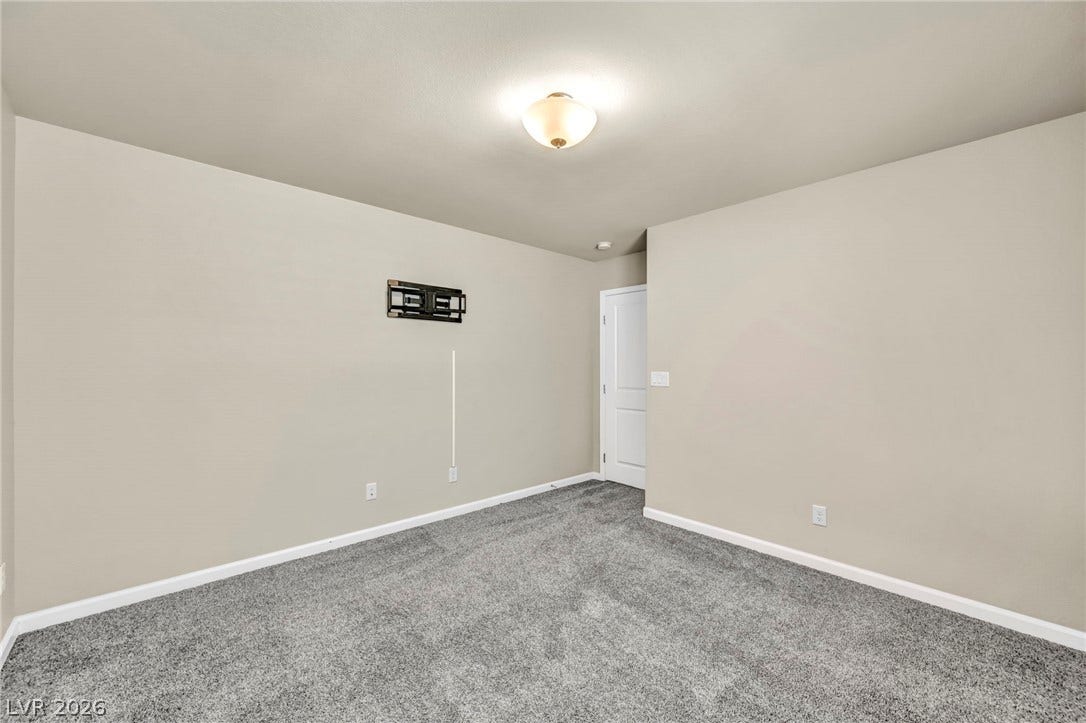 6571 Tangled Vines Avenue, Las Vegas, NV 89139 Plush carpeting anchors this versatile interior space featuring clean lines and a classic panel door.