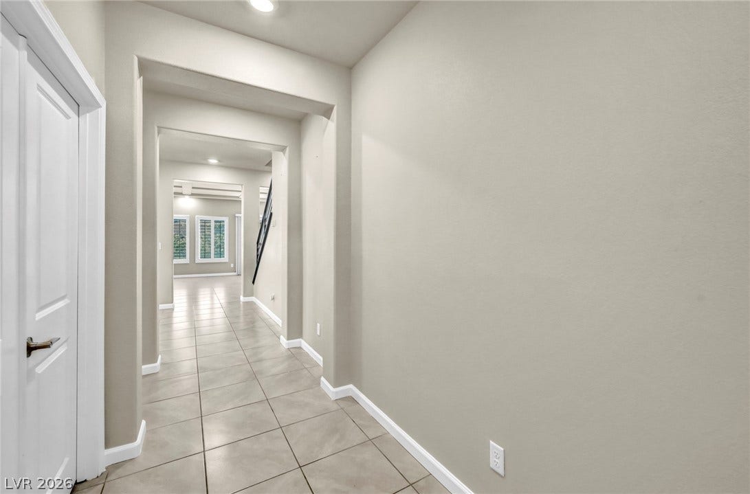 6571 Tangled Vines Avenue, Las Vegas, NV 89139 A welcoming arched entryway features durable tile flooring and clean architectural lines.