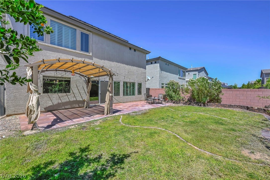 6571 Tangled Vines Avenue, Las Vegas, NV 89139 A spacious grassy lawn and tiled patio define this private backyard setting.