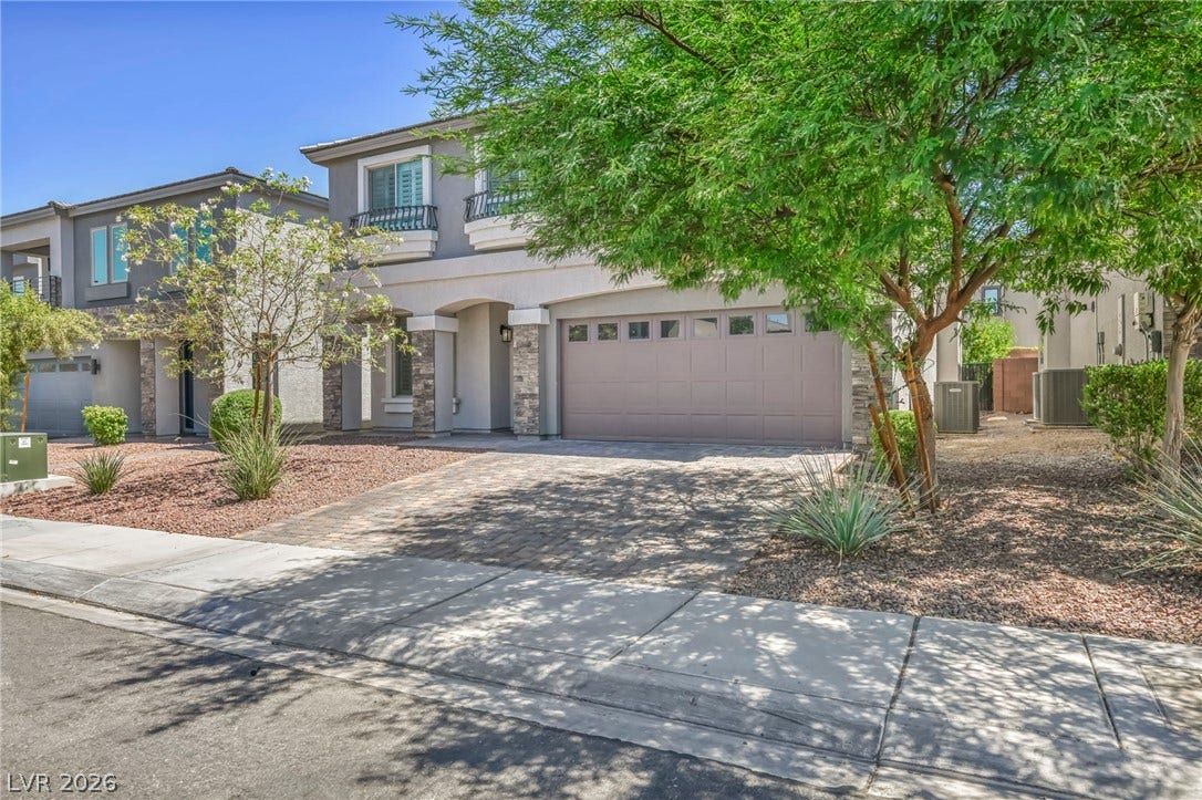 6571 Tangled Vines Avenue, Las Vegas, NV 89139 Stone accents and a paved driveway enhance the exterior of this multi-level home.