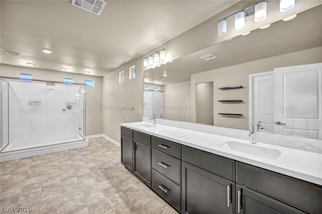 6571 Tangled Vines Avenue, Las Vegas, NV 89139 A spacious double vanity and a glass-enclosed shower highlight this modern bathroom.