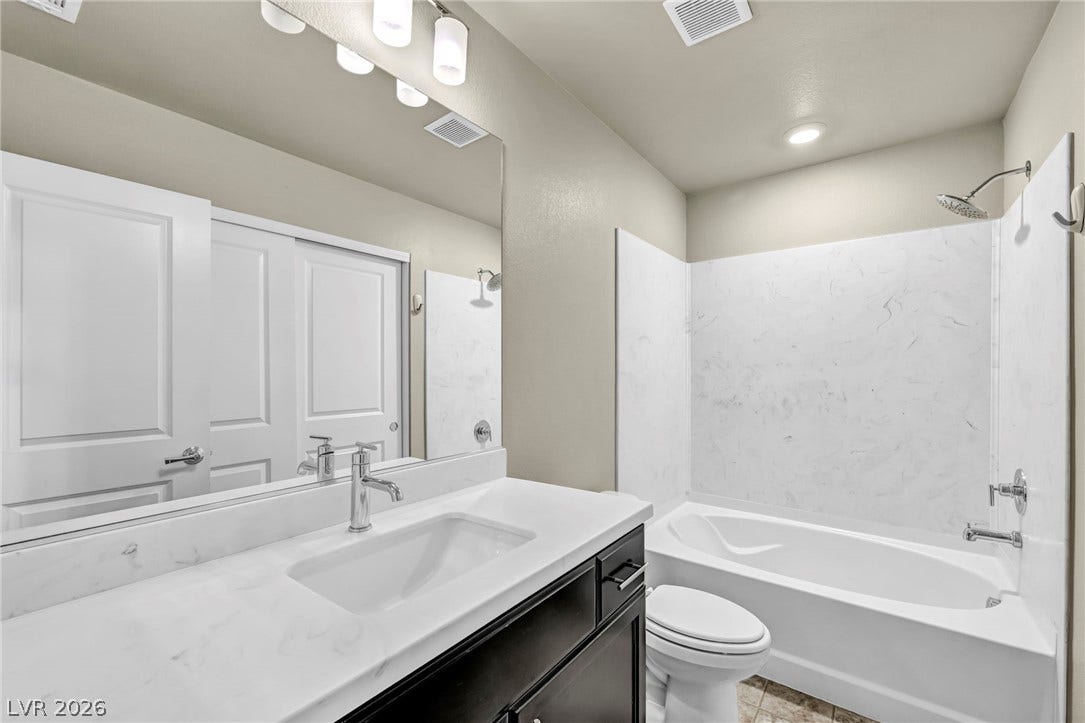 6571 Tangled Vines Avenue, Las Vegas, NV 89139 A modern vanity with solid countertops pairs beautifully with a clean tub and shower surround.
