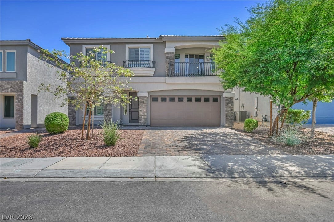 6571 Tangled Vines Avenue, Las Vegas, NV 89139 An elegant exterior showcases stone accents, a second-floor balcony, and a paved driveway.