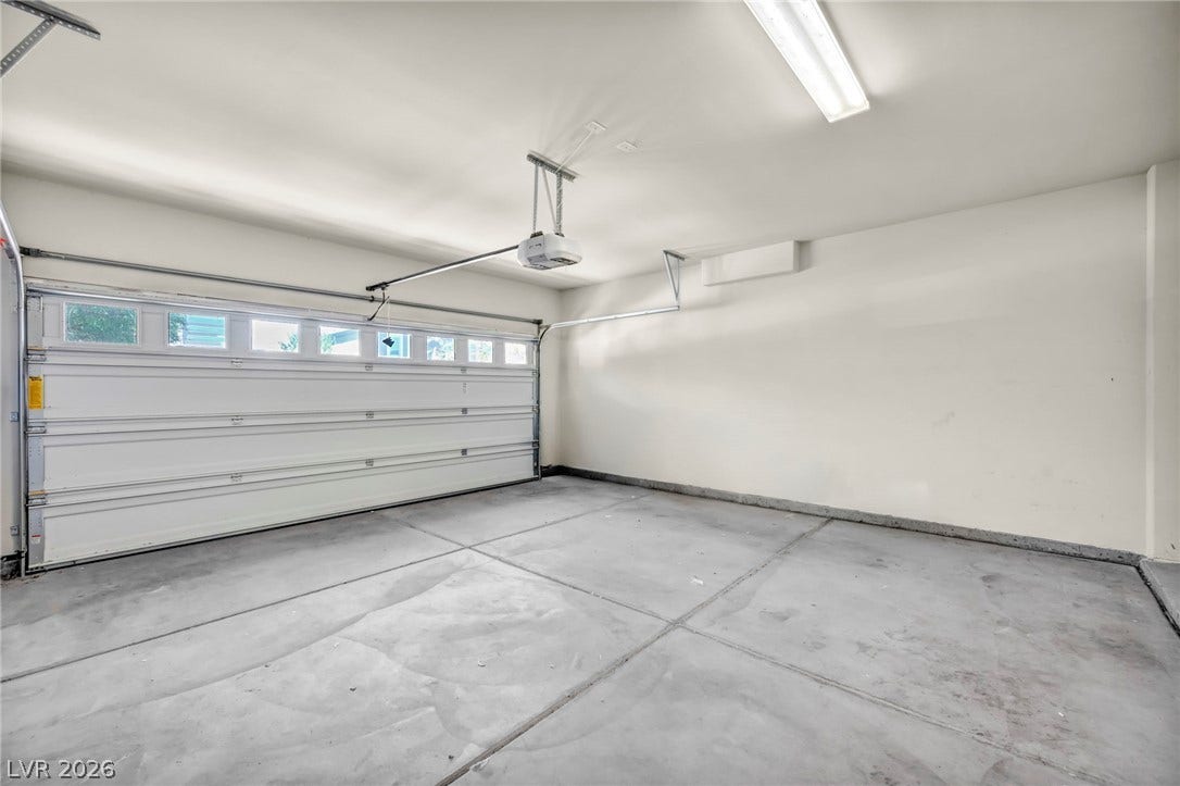 6571 Tangled Vines Avenue, Las Vegas, NV 89139 Clean concrete flooring and a modern automatic door define this spacious garage.