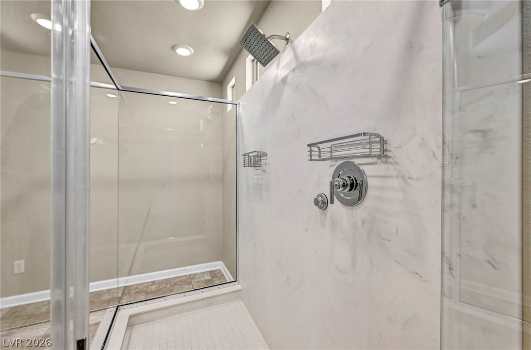 6571 Tangled Vines Avenue, Las Vegas, NV 89139 Crisp stone shower surrounds and modern chrome fixtures highlight this contemporary bathroom design.