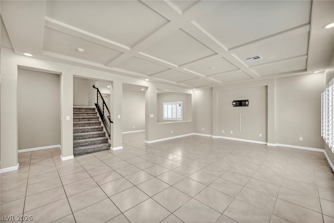 6571 Tangled Vines Avenue, Las Vegas, NV 89139 An elegant coffered ceiling and neutral tile flooring define this spacious open living area.