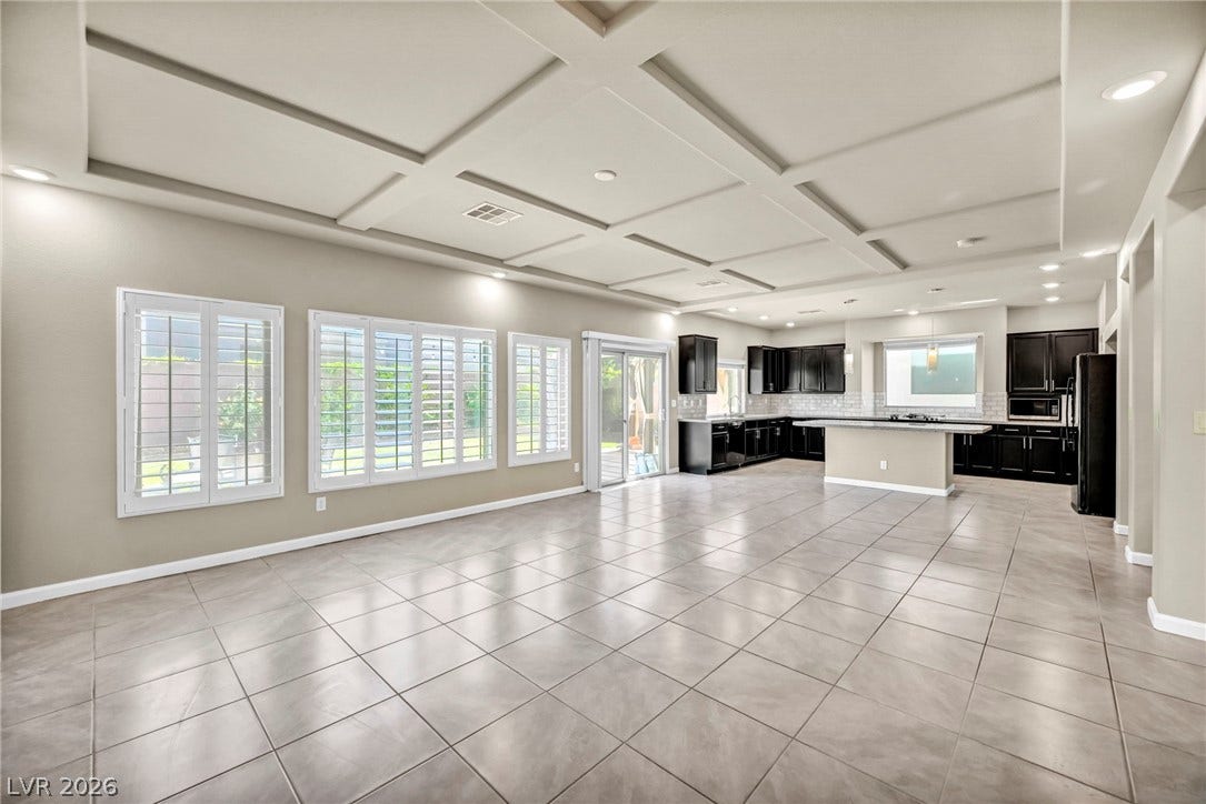 6571 Tangled Vines Avenue, Las Vegas, NV 89139 An open floorplan connects the tiled living space to the kitchen beneath coffered ceilings.