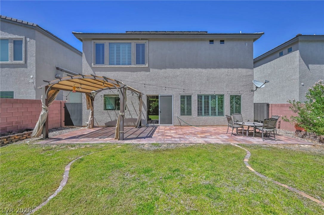 6571 Tangled Vines Avenue, Las Vegas, NV 89139 A spacious stone patio and grassy yard define the rear of this stucco home.