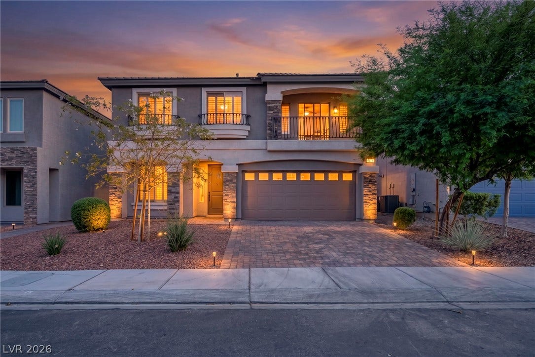 6571 Tangled Vines Avenue, Las Vegas, NV 89139 An elegant stone-accented facade showcases a paved driveway and structured desert landscaping.