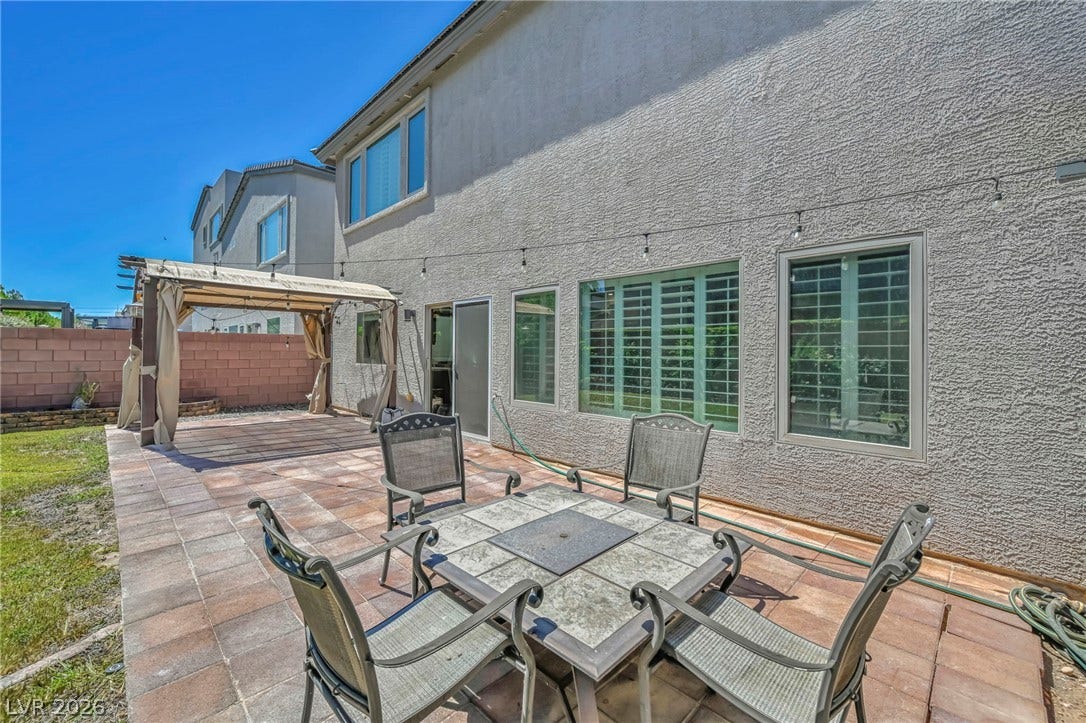 6571 Tangled Vines Avenue, Las Vegas, NV 89139 An inviting paved patio sits beneath the stucco exterior of this multi-level home.