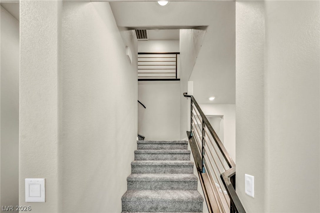 6571 Tangled Vines Avenue, Las Vegas, NV 89139 Modern metal railings and plush carpeting define this clean, soaring stairway transition.