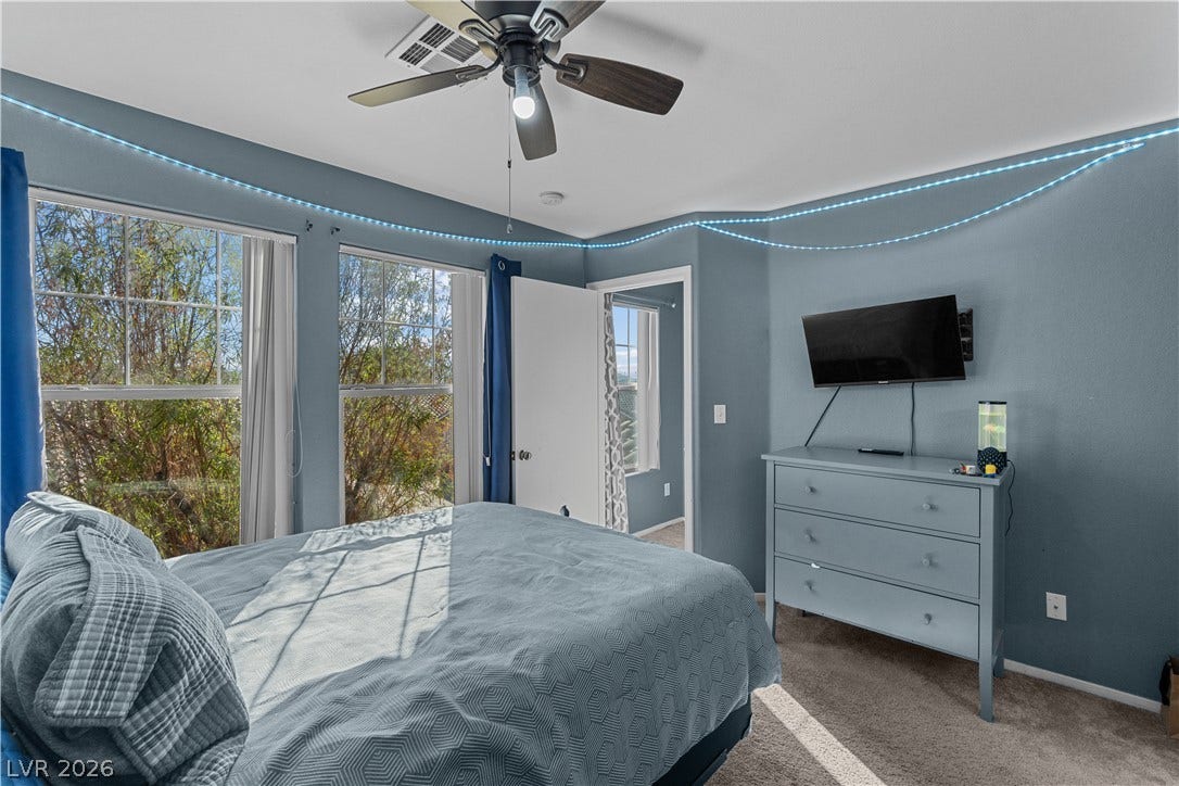 5015 Droubay Drive, Las Vegas, NV 89122 Tall windows frame peaceful outdoor views in this comfortable bedroom space.