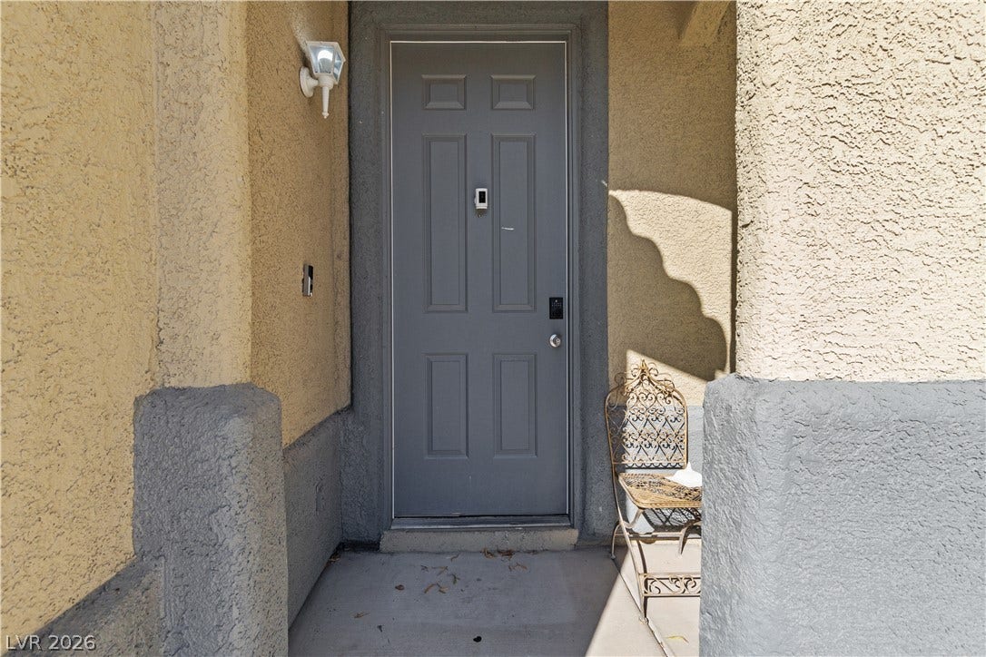 5015 Droubay Drive, Las Vegas, NV 89122 A recessed entrance is framed by stucco pillars and textured walls leading to the front door.