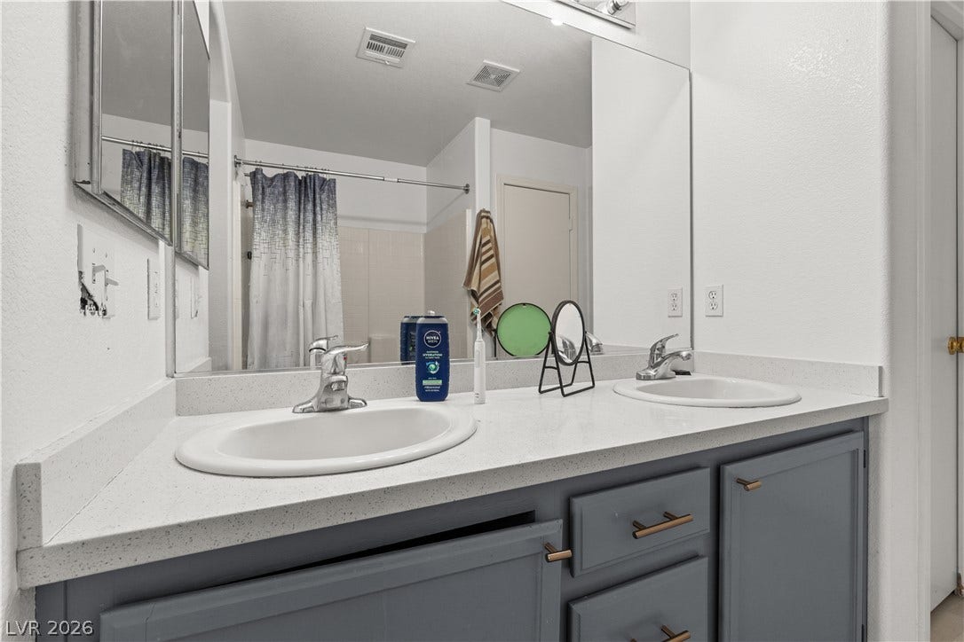 5015 Droubay Drive, Las Vegas, NV 89122 A spacious double vanity features a solid surface countertop and ample cabinet storage.