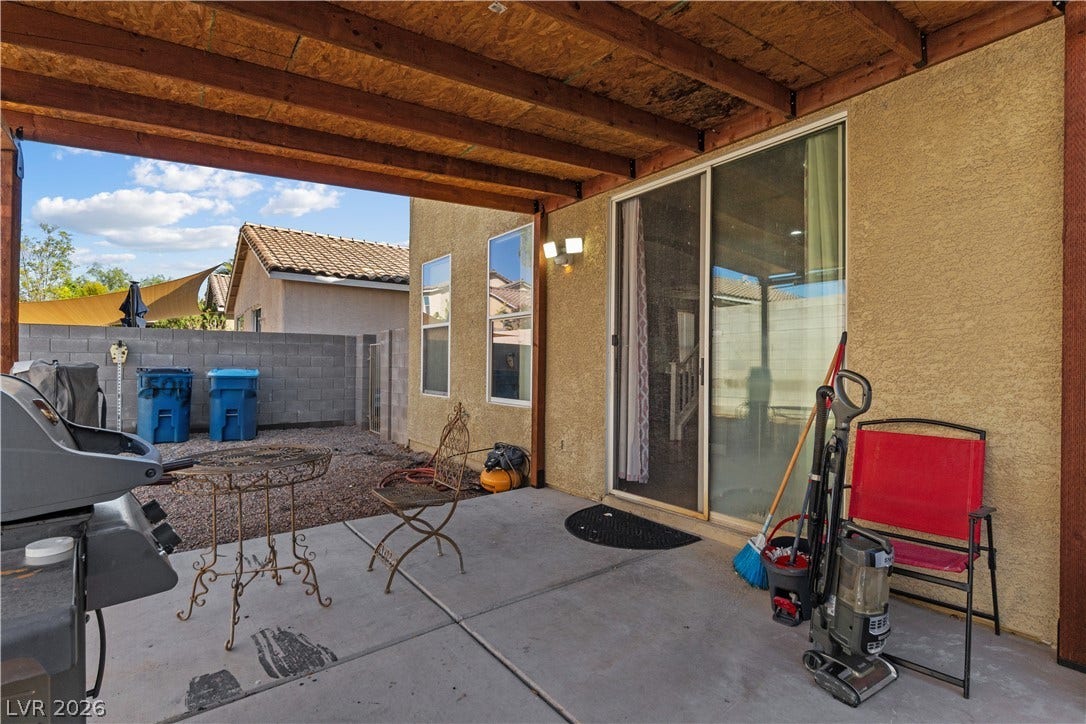 5015 Droubay Drive, Las Vegas, NV 89122 Shaded concrete patio features an overhead wood structure and sliding glass door access.