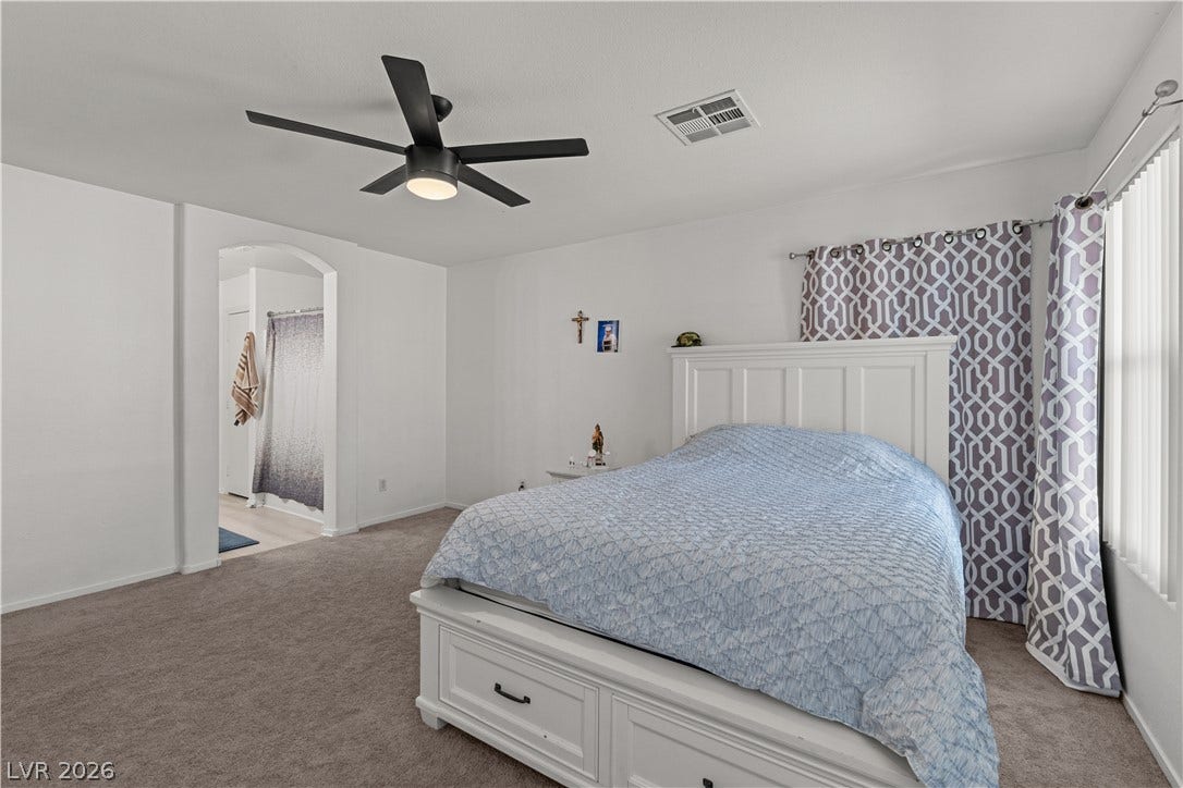 5015 Droubay Drive, Las Vegas, NV 89122 Plush carpeting anchors this comfortable bedroom suite featuring an arched doorway to the adjacent bath.