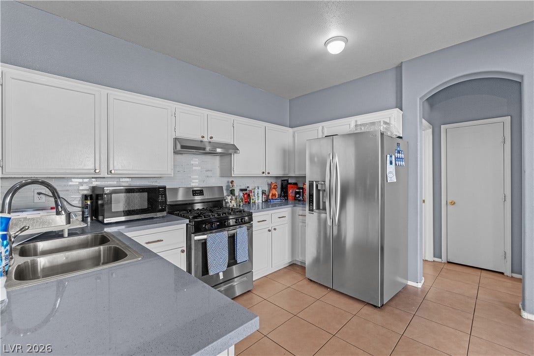 5015 Droubay Drive, Las Vegas, NV 89122 Gleaming stone countertops and crisp white cabinetry line this efficiently designed cooking space.