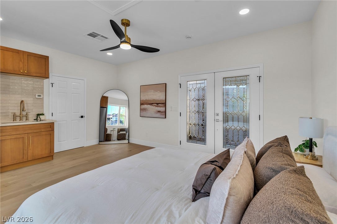 2734 Cherrydale Falls Drive, Henderson, NV 89052 Double doors open to the outdoors in this generous bedroom suite with rich wood flooring.