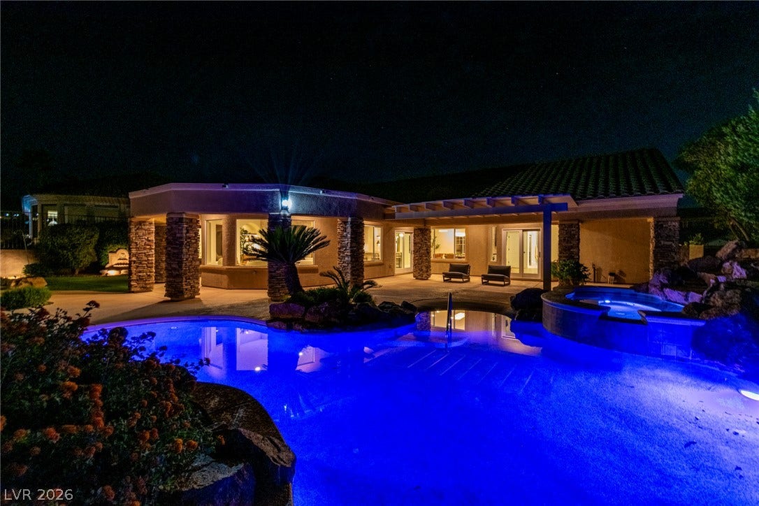 2734 Cherrydale Falls Drive, Henderson, NV 89052 Dramatic night lighting accentuates the outdoor pool and stone pillars of this modern backyard retreat.