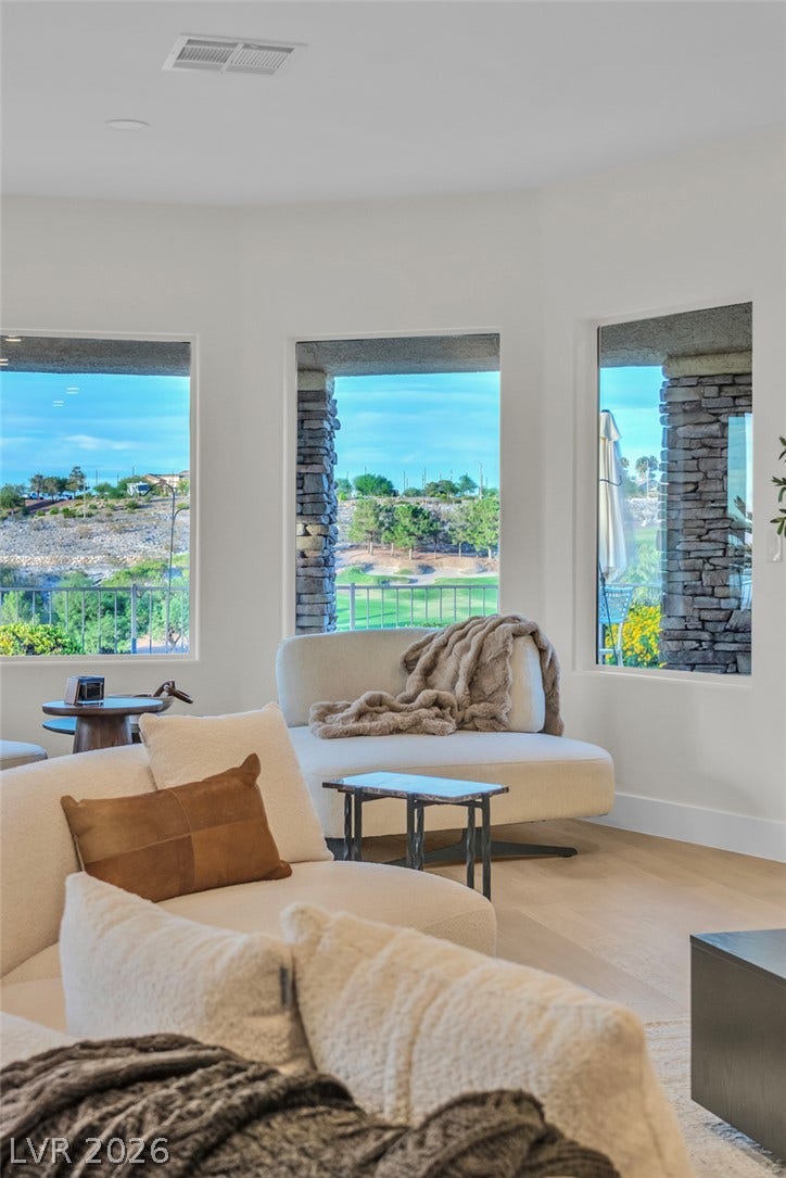 2734 Cherrydale Falls Drive, Henderson, NV 89052 Large picture windows frame expansive views of the golf course and surrounding hills.