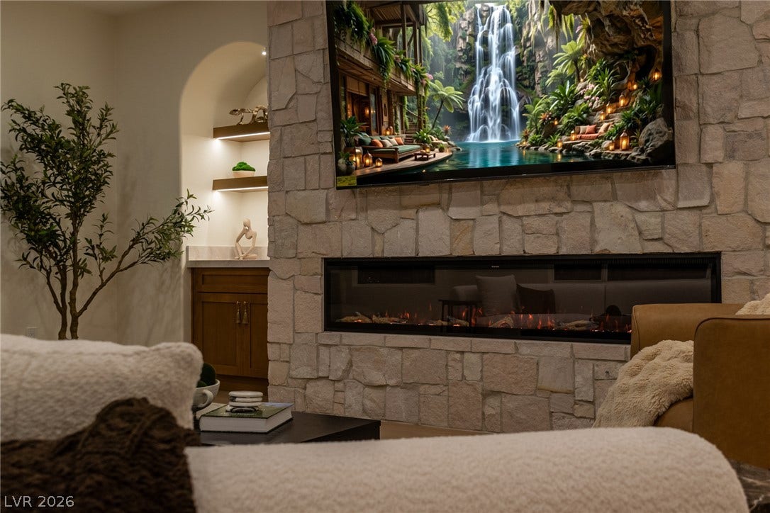 2734 Cherrydale Falls Drive, Henderson, NV 89052 A modern stone fireplace serves as a striking centerpiece in this inviting living space.