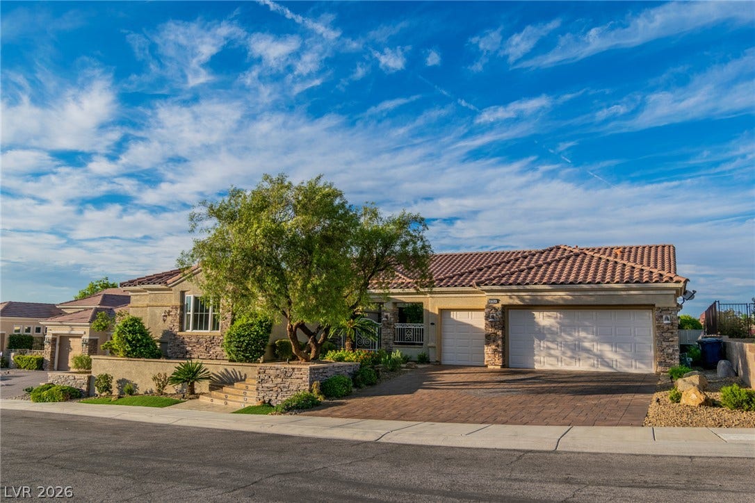 2734 Cherrydale Falls Drive, Henderson, NV 89052 Stone accents and a tile roof define this elegant facade with a paved driveway.