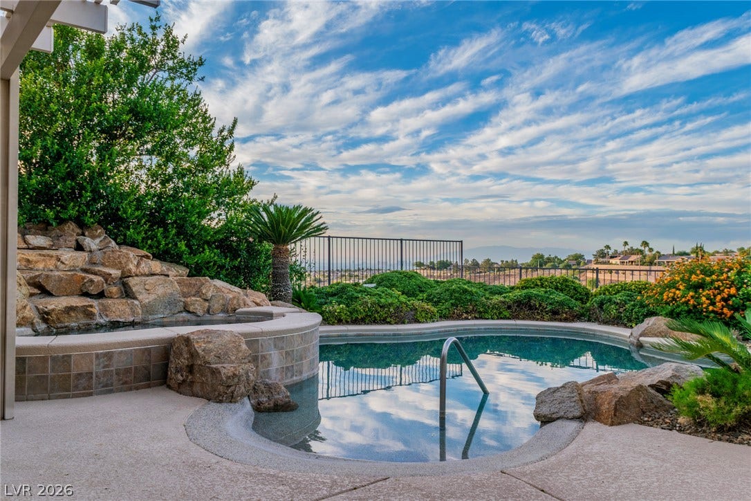 2734 Cherrydale Falls Drive, Henderson, NV 89052 An inviting backyard pool framed by natural rock formations overlooks sweeping valley vistas.