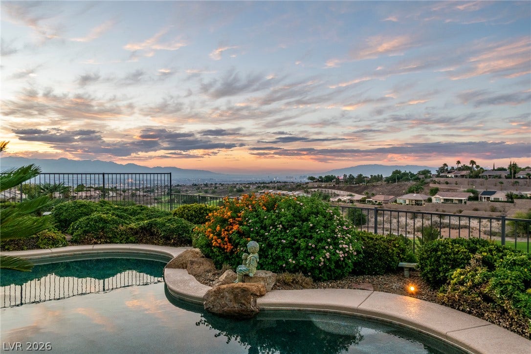 2734 Cherrydale Falls Drive, Henderson, NV 89052 An inviting backyard pool overlooks panoramic valley and distant mountain vistas under a sunset sky.