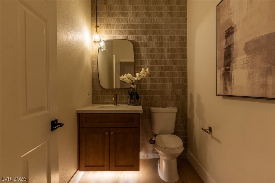 2734 Cherrydale Falls Drive, Henderson, NV 89052 Textured tile backdrops a floating vanity in this thoughtfully designed powder room.