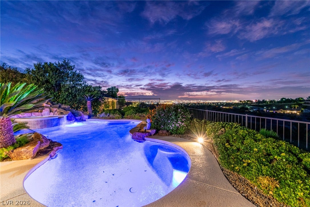 2734 Cherrydale Falls Drive, Henderson, NV 89052 Panoramic city lights and distant mountain views frame this backyard oasis with a sparkling pool.