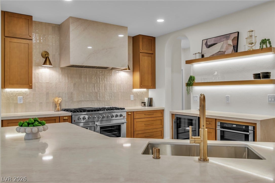 2734 Cherrydale Falls Drive, Henderson, NV 89052 Warm wood cabinetry and stone counters highlight this meticulously designed culinary space.