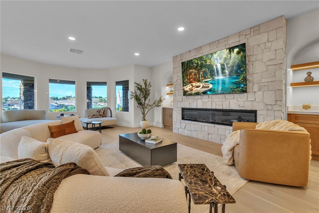 2734 Cherrydale Falls Drive, Henderson, NV 89052 An impressive stone fireplace anchors the bright living space featuring smooth wood flooring.