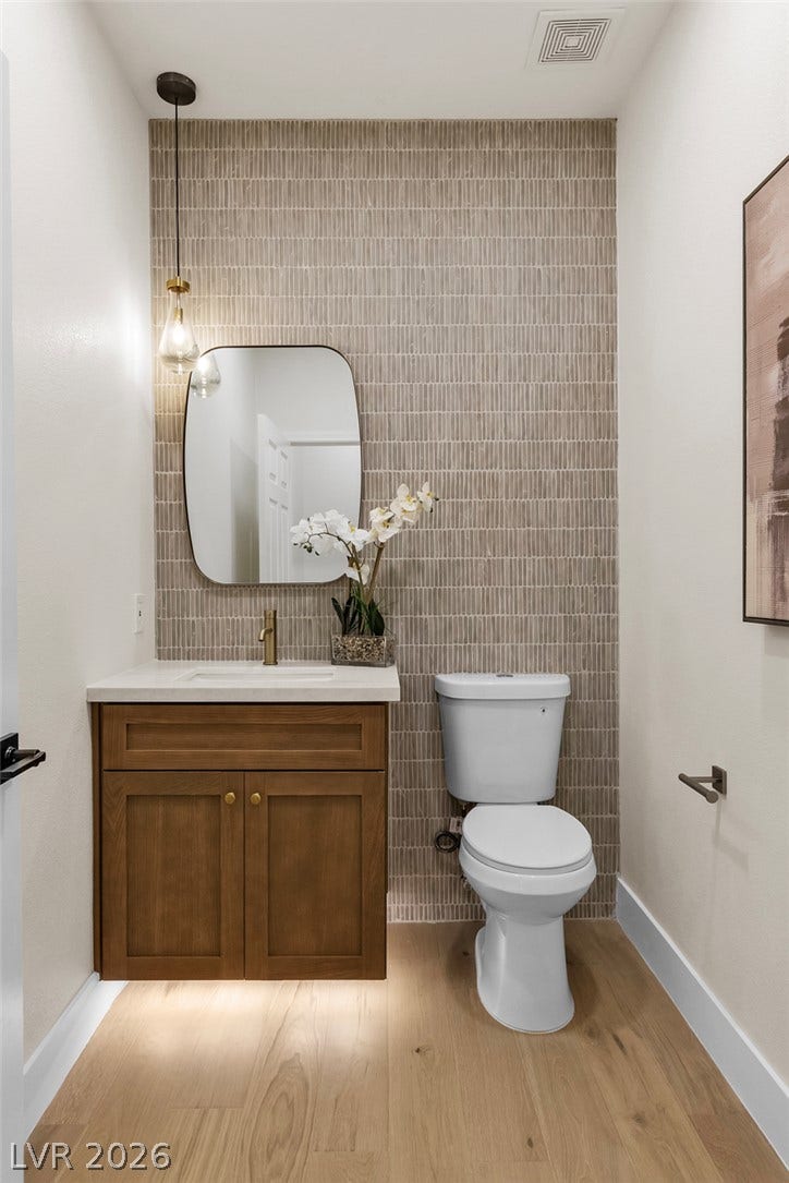 2734 Cherrydale Falls Drive, Henderson, NV 89052 Elegant textured tiling accents the vanity wall above smooth wood flooring.