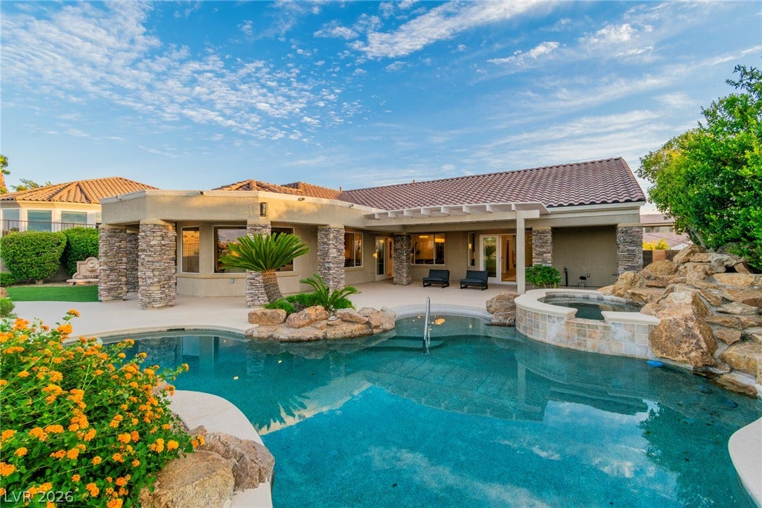 2734 Cherrydale Falls Drive, Henderson, NV 89052 An inviting backyard pool oasis features stone accents, integrated spa, and a covered patio area.