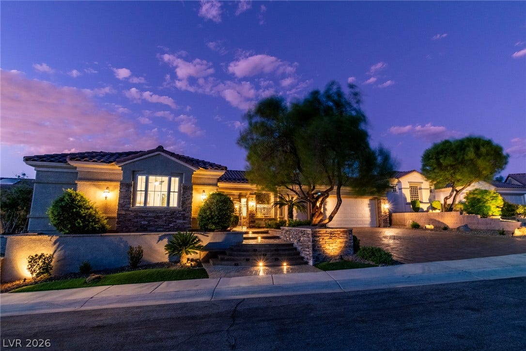 2734 Cherrydale Falls Drive, Henderson, NV 89052 Stone accents and custom integrated lighting elevate this multi-level modern facade under twilight skies.