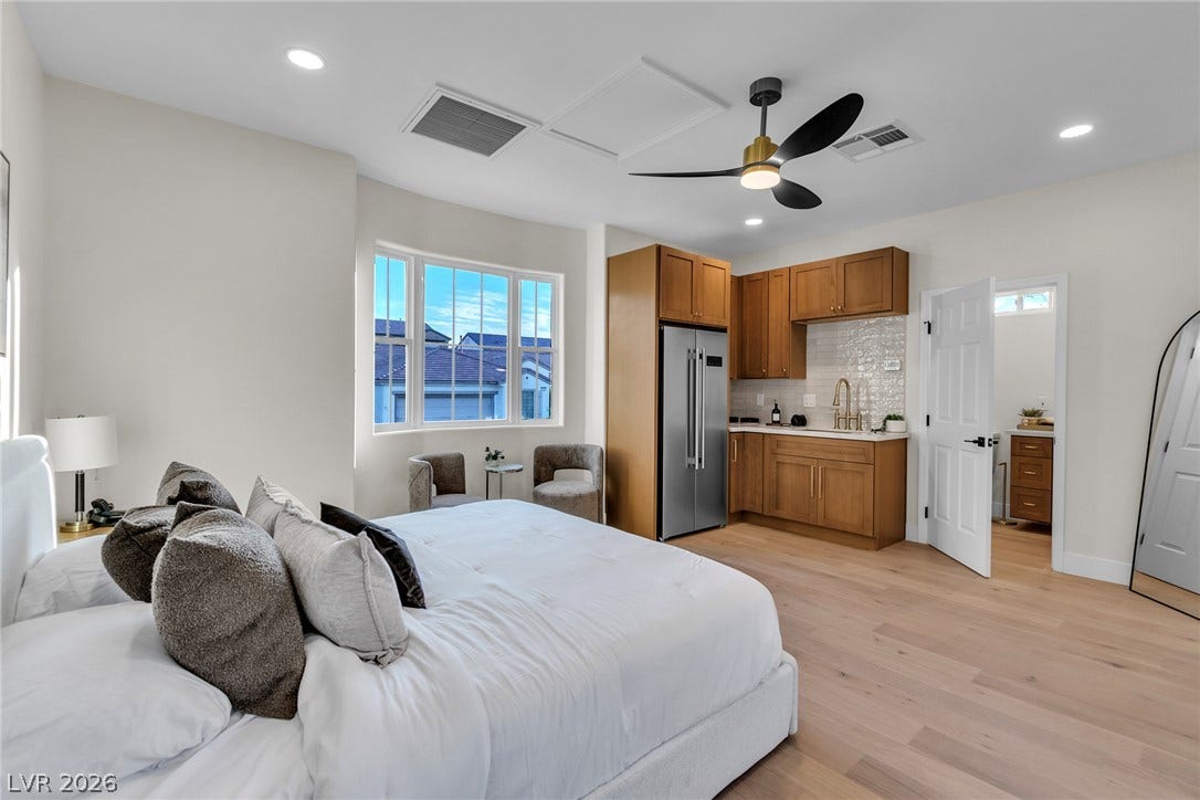 2734 Cherrydale Falls Drive, Henderson, NV 89052 A spacious bedroom suite features light hardwood floors and a convenient wet bar area.