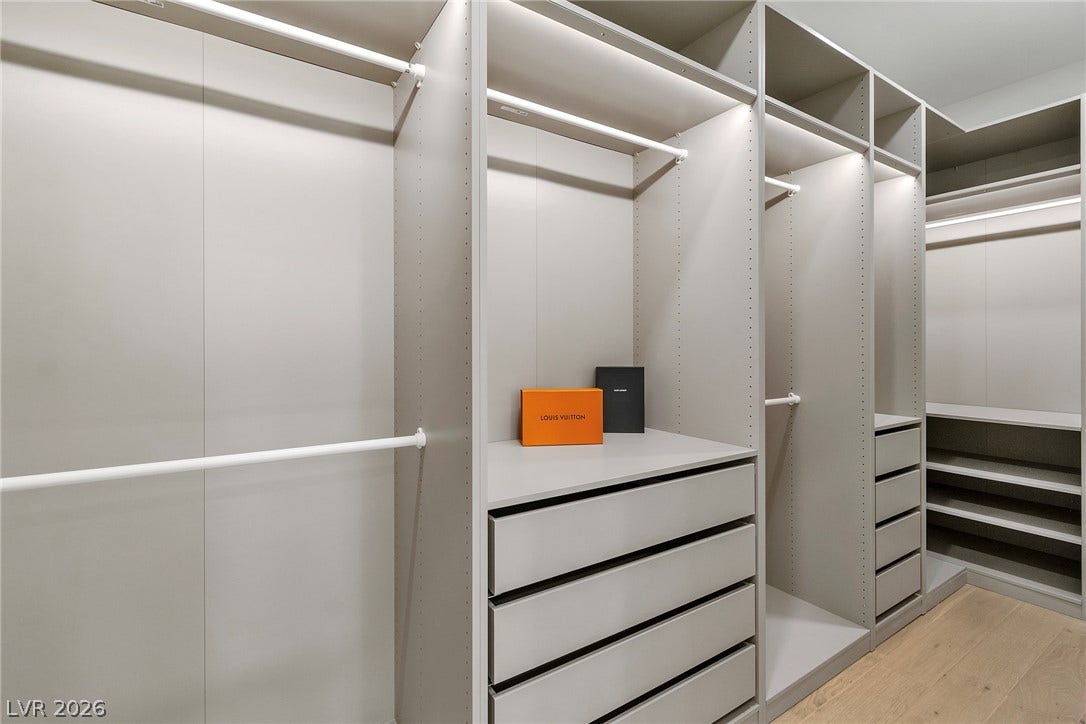 2734 Cherrydale Falls Drive, Henderson, NV 89052 Custom built-in shelving and integrated lighting define this organized wardrobe space.