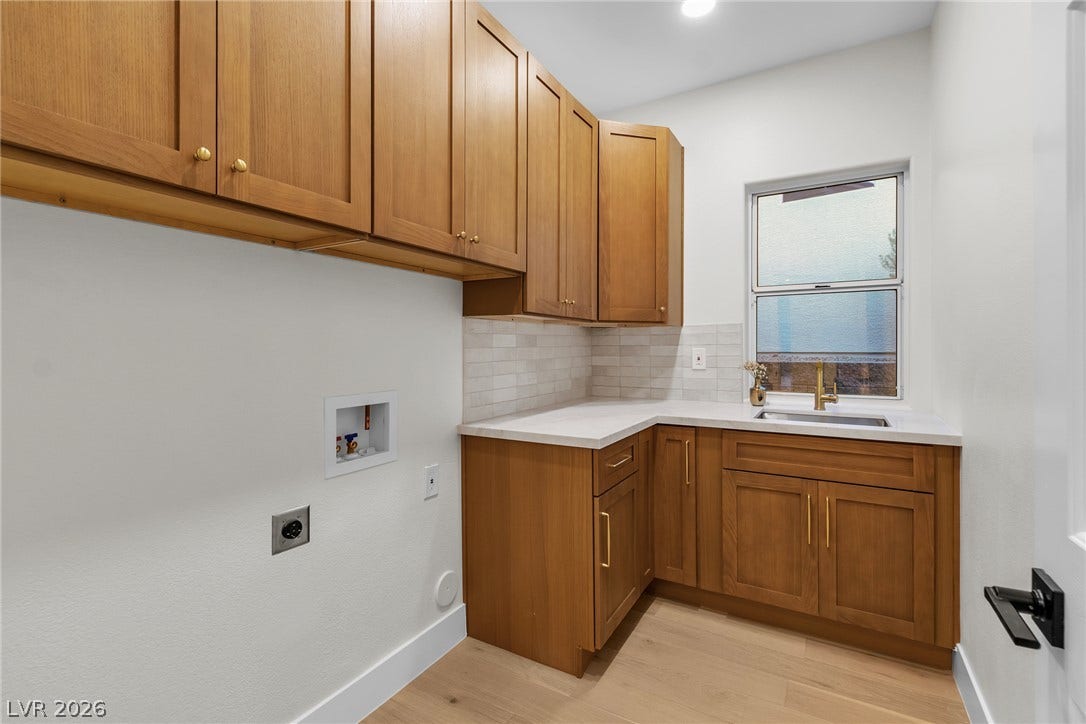 2734 Cherrydale Falls Drive, Henderson, NV 89052 Ample wooden cabinetry and a built-in utility sink define this functional chore station.