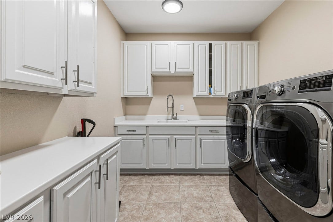 204 Satin Mist Court, Las Vegas, NV 89144 Ample white cabinetry and durable tile flooring highlight this functional laundry space.