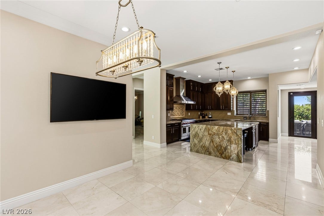 204 Satin Mist Court, Las Vegas, NV 89144 Polished tile flooring flows seamlessly into a gourmet kitchen featuring a striking waterfall island.