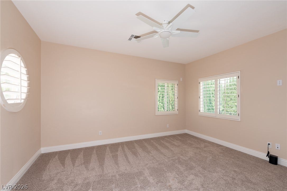 204 Satin Mist Court, Las Vegas, NV 89144 Plentiful natural light filters through plantation shutters into this carpeted bedroom.