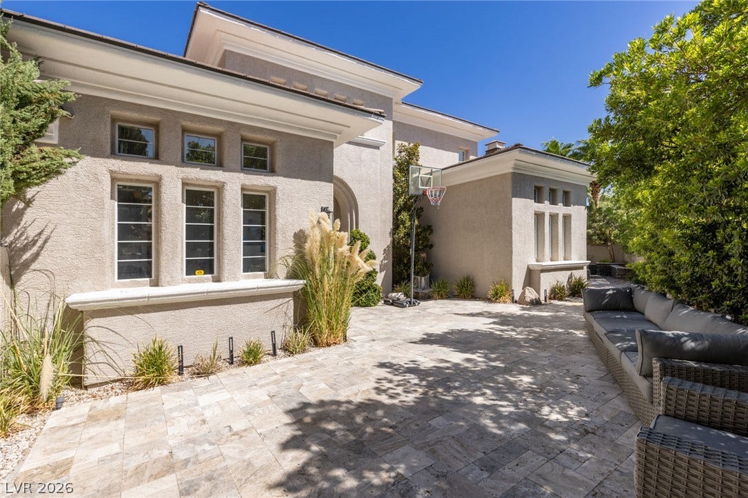 204 Satin Mist Court, Las Vegas, NV 89144 Sunlight washes over the stone-paved courtyard nestled against the stucco exterior of this modern home.