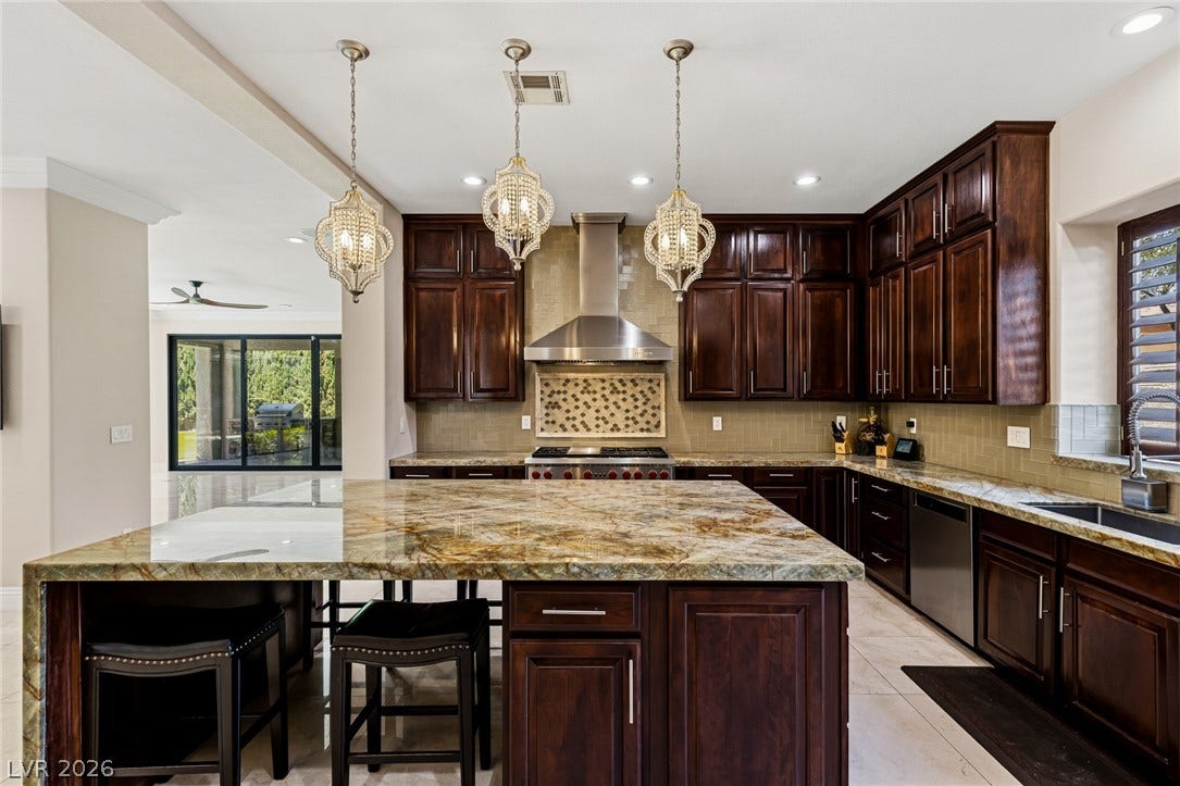 204 Satin Mist Court, Las Vegas, NV 89144 Gleaming stone countertops and dark wood cabinetry define this gourmet kitchen space.