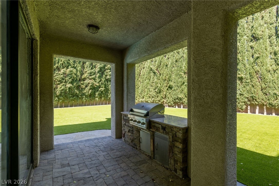 204 Satin Mist Court, Las Vegas, NV 89144 An integrated outdoor kitchen elements are built into stone beneath a sheltered patio structure.