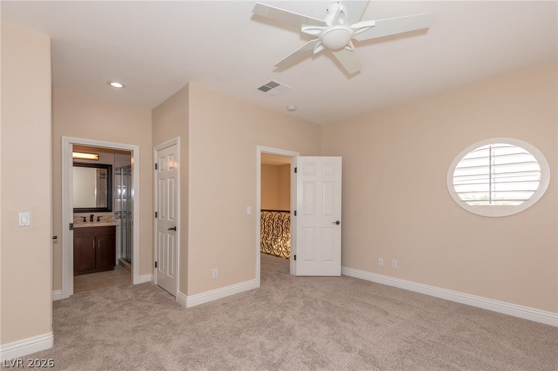 204 Satin Mist Court, Las Vegas, NV 89144 An oval window and plush carpeting define this comfortable bedroom with an attached bathroom.