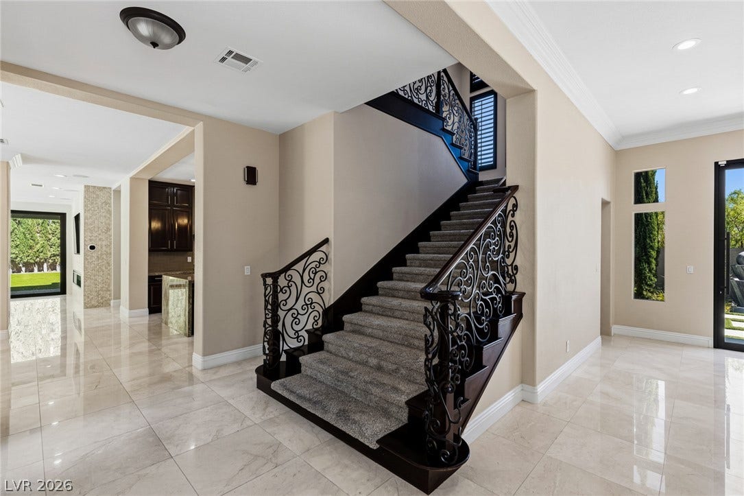 204 Satin Mist Court, Las Vegas, NV 89144 Polished stone flooring and an ornate wrought-iron staircase define this grand entryway.