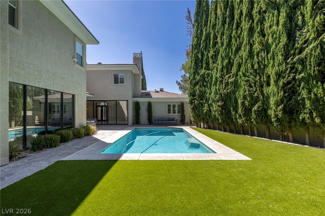 204 Satin Mist Court, Las Vegas, NV 89144 Lush landscaping and pristine turf frame a sparkling swimming pool in the private backyard.