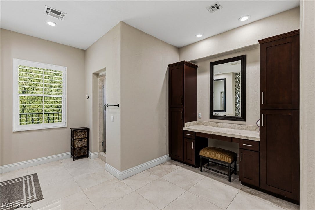 204 Satin Mist Court, Las Vegas, NV 89144 Rich dark wood built-ins and pristine stone flooring define this elegant dressing area.