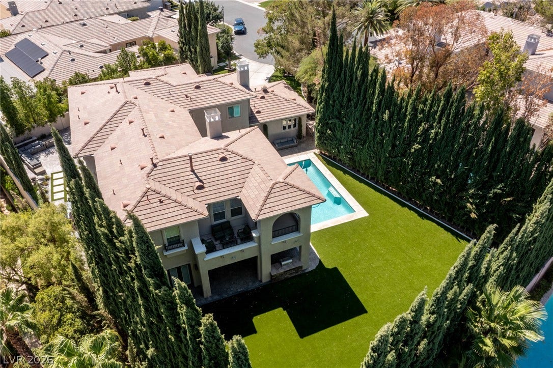 204 Satin Mist Court, Las Vegas, NV 89144 An elevated perspective showcases the private swimming pool and manicured lawn of this modern estate.