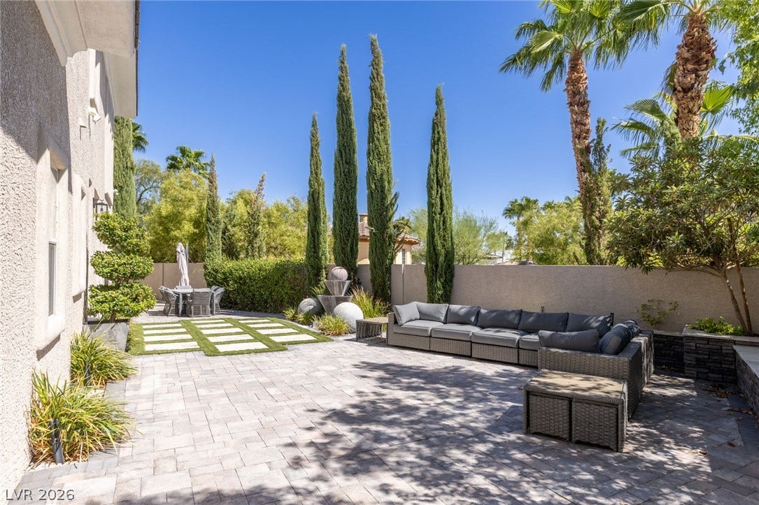 204 Satin Mist Court, Las Vegas, NV 89144 Manicured hedges, pavers, and soaring palms shape a private backyard retreat.